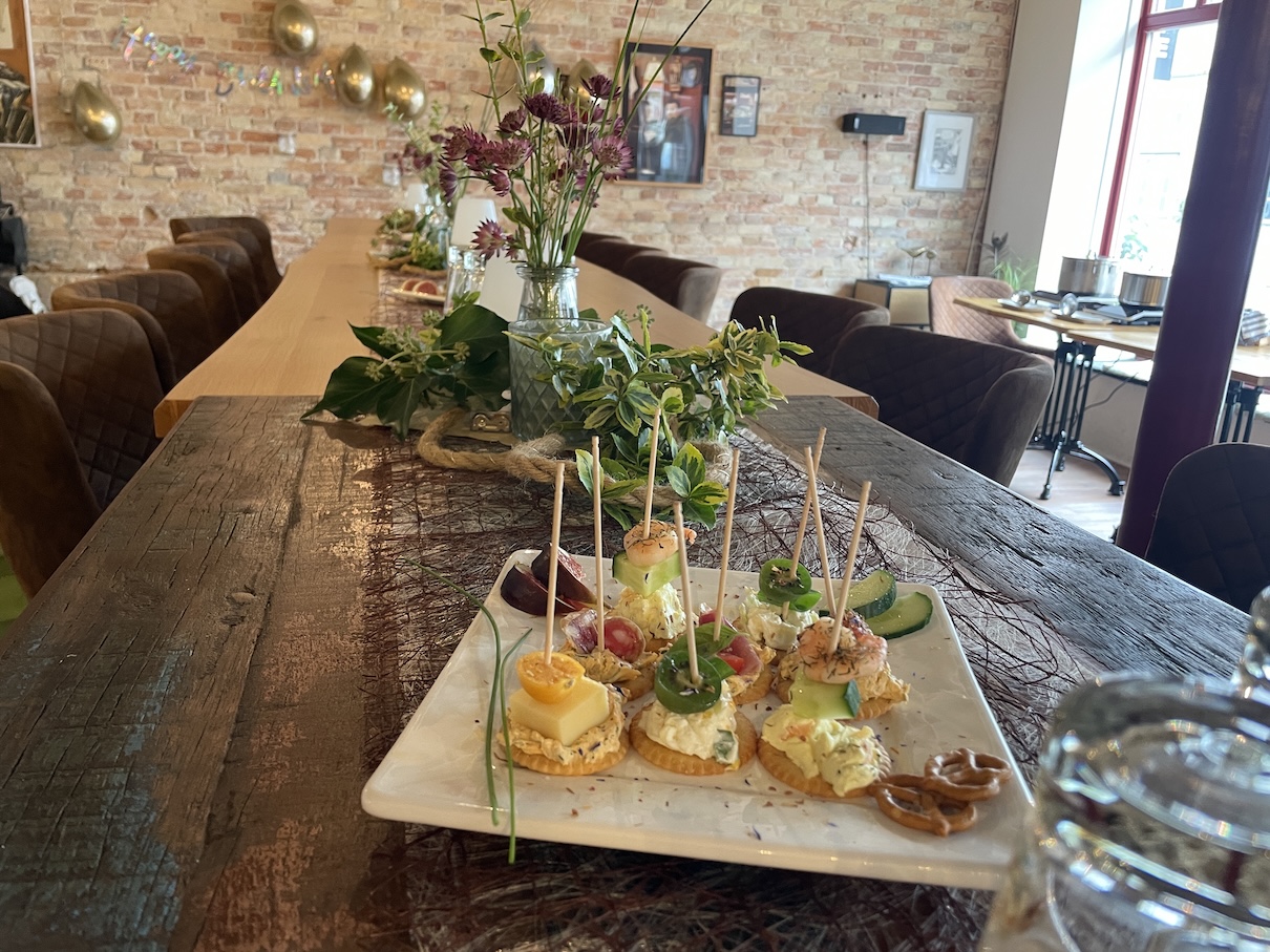 Ein Teller mit Häppchen auf einem rustikalen Holztisch.