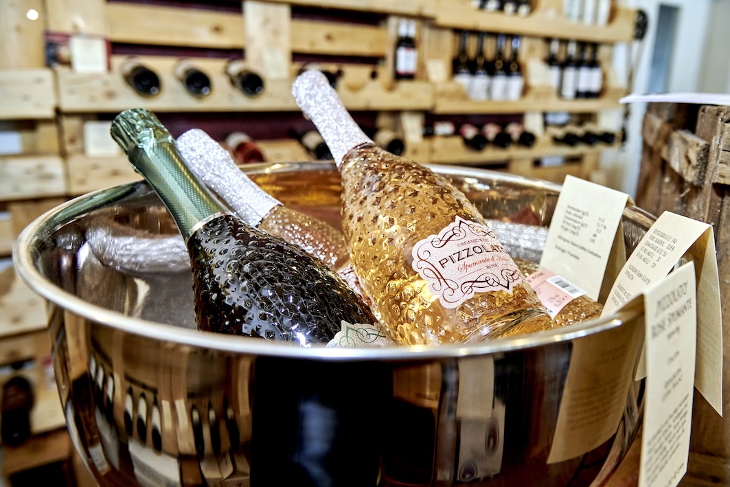 Mehrere Weinflaschen liegen in einer Edelstahlschüssel.